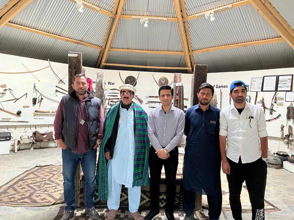 Visitors posing inside the Heritage Museum Laspur with traditional weapon and artifact displays