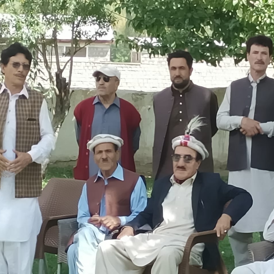 Group portrait of community members in a garden in Chitral