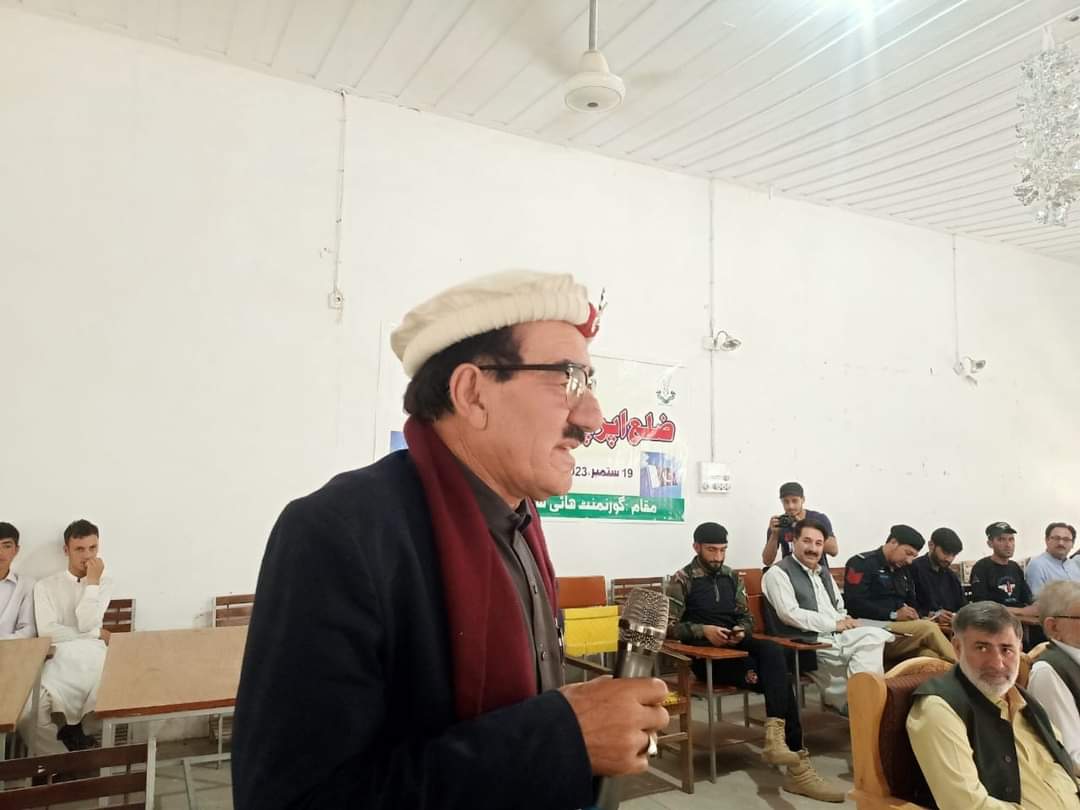 Speaker addressing a community meeting at a government hall in Upper Chitral