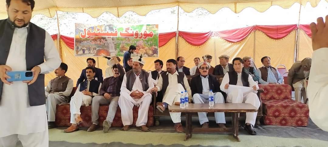Large gathering under decorated tent at outdoor event