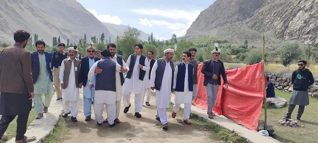 Group walking in mountain valley with red flag