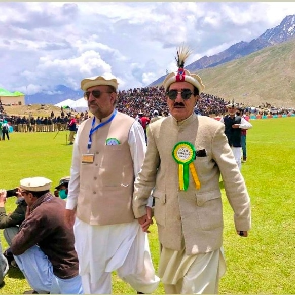 Large gathering under tent with mountains in background