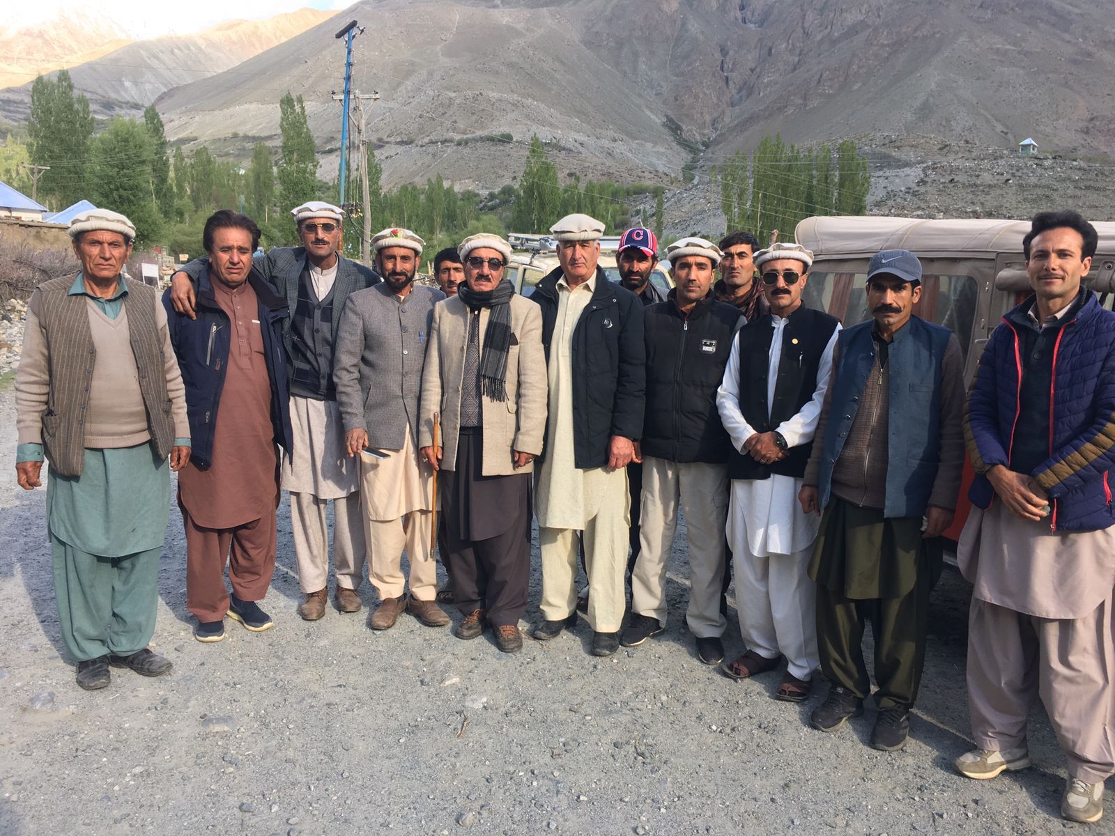 Group of community members posing in a mountain valley in Chitral
