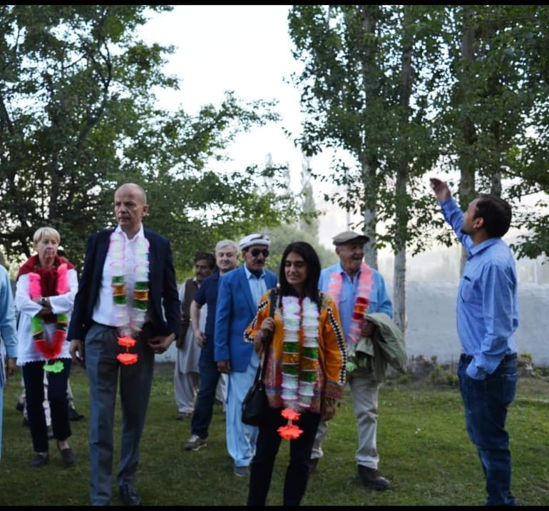 International dignitaries escorted through the museum garden with traditional garlands