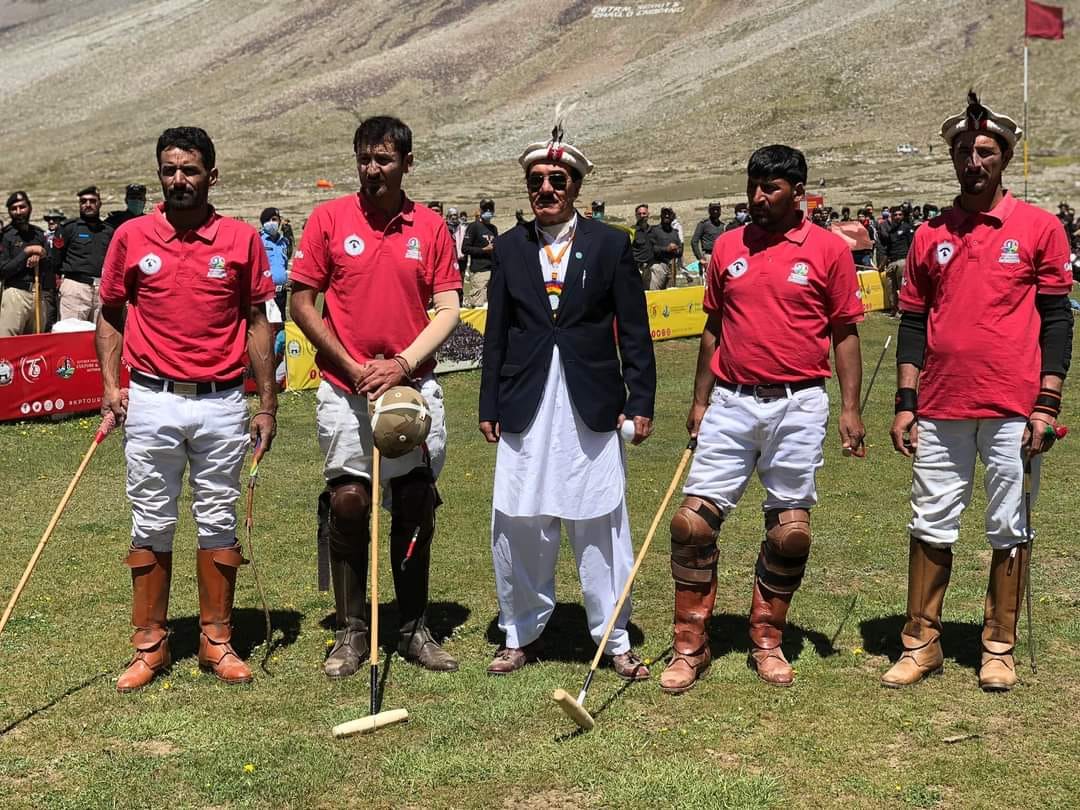 Polo rider in red jersey charging on horseback during Shandur match