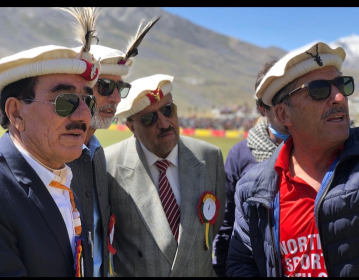 Distinguished guests at the Shandur Polo Festival with polo ground and mountains behind