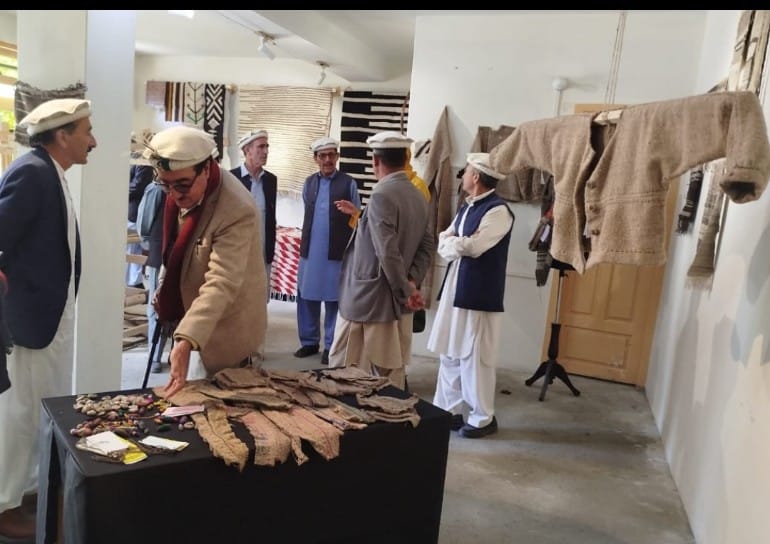 Museum visitors examining textiles and cultural artifacts